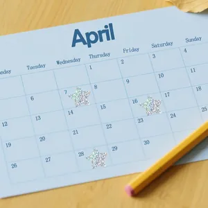 Macro view of glittering holographic star stickers placed on a paper calendar page