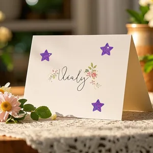 Close-up detail of shiny purple glitter star stickers applied on a decorative floral card