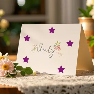 Close-up of purple pentagram star stickers applied on a decorative greeting card