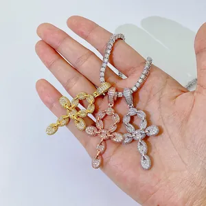 Hand-held view of three iced-out Ankh cross pendants in gold, rose gold, and silver