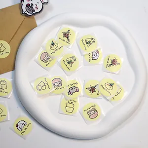Vista dall'alto di simpatici adesivi 'thank you' su un piatto di ceramica bianca