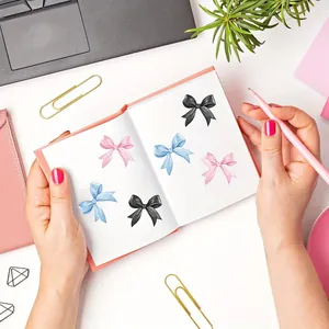 Detailopname van decoratieve strikstickers in roze, blauw en zwart in een schrift