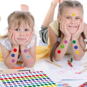 Detail view of two children enjoying colorful smiley face reward stickers during art activities