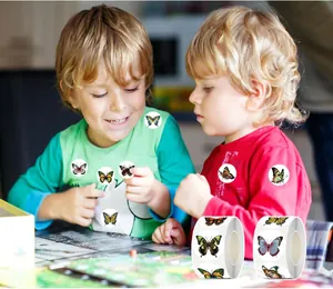 Detalle de niños usando pegatinas de mariposas de 1 pulgada para decorar la ropa.