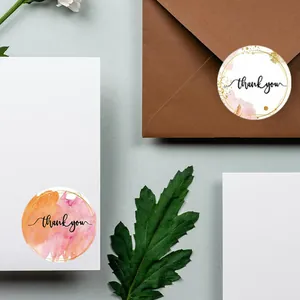 Détail d'autocollants ronds merci à l'aquarelle sur enveloppe brune et carte blanche
