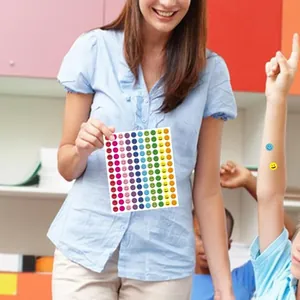 Teacher holding sheet of colorful smiley face reward stickers in a classroom setting