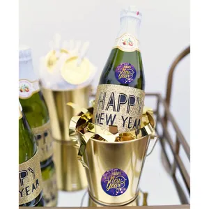 Happy New Year labels on champagne bottles in a festive gold ice bucket setting