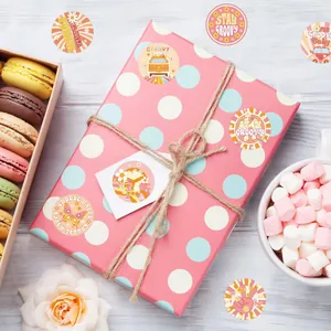 Autocollants marguerite hippie boho décorant une boîte cadeau rose à pois pour fête
