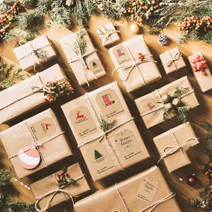 Gros plan d'étiquettes de Noël en papier kraft appliquées sur des cadeaux emballés.