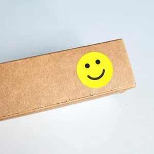 Close-up of a vibrant yellow smiley face reward sticker applied on a brown kraft box