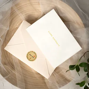 Primer plano de pegatinas de papel kraft floral en sobre de regalo y tarjeta