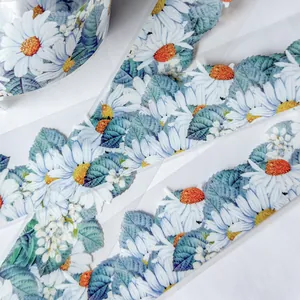Detailed macro view of decorative PET tape featuring white daisy flowers and green leaf print
