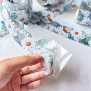 Close-up of transparent PET tape featuring delicate daisy patterns for DIY scrapbooking