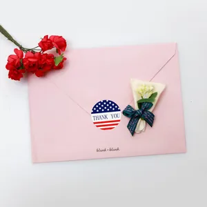 Close-up detail of 1-inch American flag Thank You sealing sticker on a pink envelope