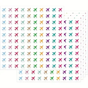 Primo piano di fogli multipli con mini adesivi colorati a forma di aereo per decorare