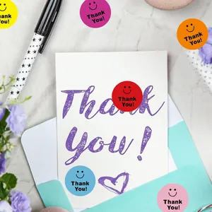 Autocollants colorés Thank You avec smiley sur une carte de vœux et une enveloppe