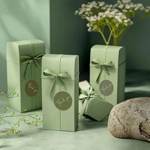 Macro view of 1 inch round green 'Thank You' sealing labels on elegant gift boxes.