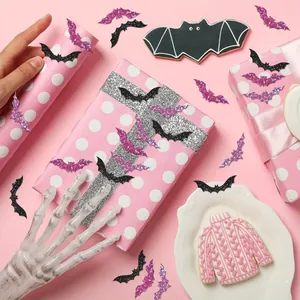 Gros plan de stickers chauve-souris laser violets sur un emballage cadeau rose