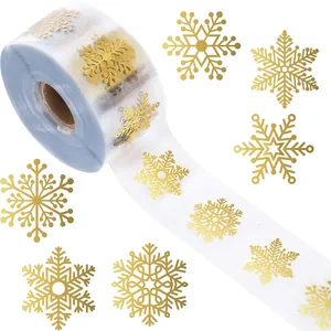 Goudfolie sneeuwvlok stickers op transparante rol voor kerstcadeauverpakking detail.