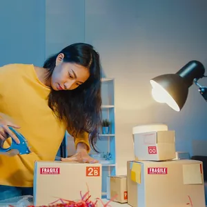 Λεπτομέρεια από κόκκινα αυτοκόλλητα Fragile Handle with care σε κουτιά αποστολής δέματος