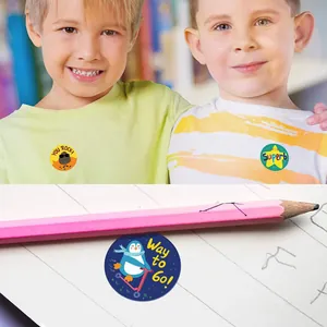 Close-up of colorful round reward stickers featuring encouraging English phrases.