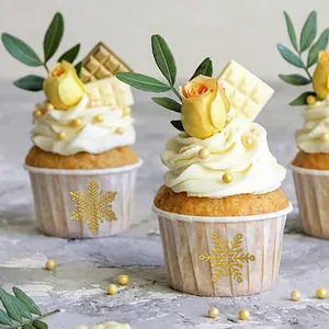 Detail van gouden sneeuwvlokstickers op cupcakevormpjes voor cadeauversiering