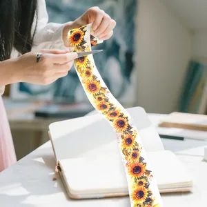 Detailopname van het knippen van zonnebloem washi-tape voor DIY-planner decor.