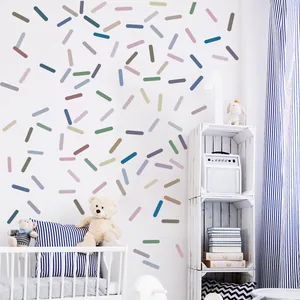 Colorful sprinkle wall decals in a nursery room setting with a baby crib and toys.