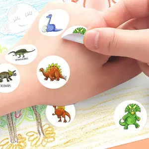 Detailed view of colorful cartoon dinosaur reward stickers applied on a child's hand