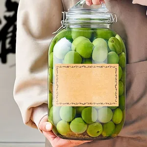 Gros plan d'une étiquette en papier kraft vierge avec bordure ornée sur un bocal en verre.