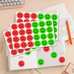 Happy and sad smiley face stickers used for decorating a personal planner notebook.