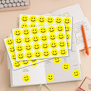 Detailed view of bright yellow smiley face reward stickers on a daily planner sheet