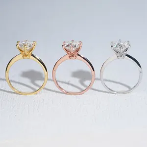 Dettaglio di tre anelli moissanite classici a 6 griffe in finiture oro, oro rosa e argento.