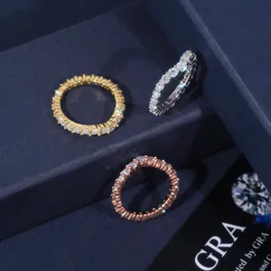 Close-up of three eternity rings in gold, silver, and rose gold with moissanite stones