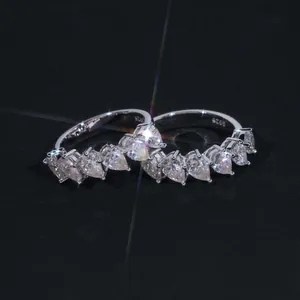 Macro detail of a sparkling S925 silver ring featuring pear-cut moissanite stones.