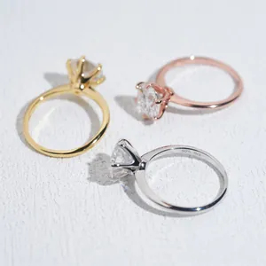 Primo piano di tre classici anelli moissanite da 3 ct a 6 griffe in oro e argento