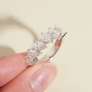 Close-up detail of a S925 sterling silver ring featuring five pear-shaped moissanite stones.