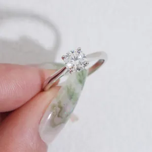 Primo piano di un anello di moissanite rotondo da 1 carato in argento a 4 griffe