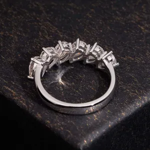 Detailed view of S925 silver half-band ring with pear-cut stones on a black box