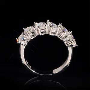 Elegant S925 silver half-eternity ring featuring pear-cut moissanite stones on black background.