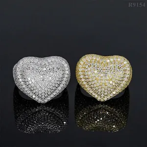 Macro view of two iced-out heart rings in silver and gold with full pave stones