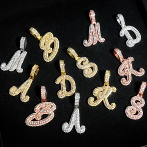 Vue détaillée de pendentifs alphabet en moissanite glacés en or, argent et or rose.