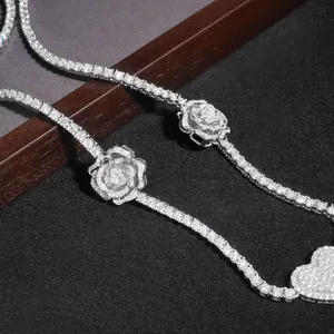 Detailansicht der silbernen Rose und Herzanhänger an einer Moissanit-Tenniskette.