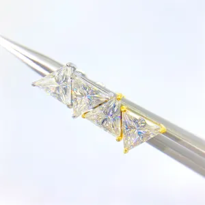 Κοντινή λήψη τεσσάρων τριγωνικών πετρών Moissanite σε βάσεις από ασήμι και χρυσό