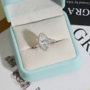 Elegante anillo de compromiso de moissanita marquesa en un estuche de joyería azul claro