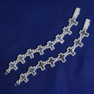 Detail view of two S925 silver bracelets with moissanite-paved cross charms on blue silk fabric.