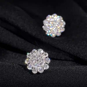 Primer plano de pendientes de flores en plata 925 con brillantes piedras de moissanita
