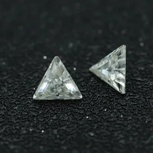 Primer plano de dos piedras de moissanita triangulares de color DF sobre un fondo negro