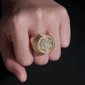 Detailaufnahme eines vergoldeten Moissanit-Cluster-Rings an einer Hand vor schwarzem Hintergrund