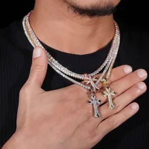 Vista dettagliata di tre ciondoli a croce hip hop in argento oro e oro rosa con moissanite